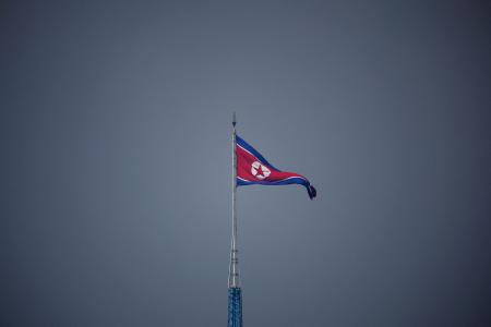 　南北軍事境界線の北側にある北朝鮮の「宣伝村」に掲げられた国旗。韓国側から撮影された＝２０２２年７月（ロイター＝共同）