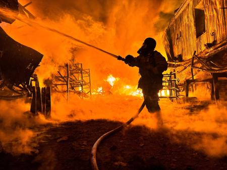 　ウクライナ東部ハリコフのロシア軍による無人機攻撃を受けた現場で消火作業に当たる消防士＝４日（ロイター＝共同）