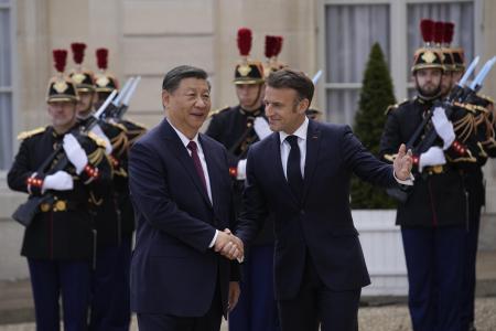 　６日、中国の習近平国家主席（左）を出迎えるフランスのマクロン大統領＝パリ（ＡＰ＝共同）
