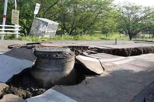 地震の激しい揺れで道路に突き出た下水道のマンホール＝２０１６年５月１６日、益城町木山（同町提供）