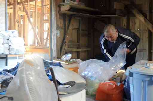 被災した自宅を片付ける上蔀行雄さん。神瀬に戻るかどうか決めかねている＝昨年１１月１１日、球磨村