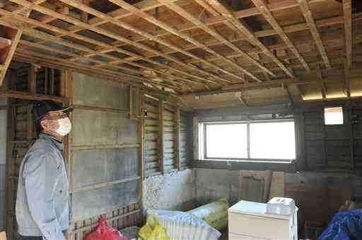 昨年７月の豪雨で浸水した自宅の修繕を続けてきた一橋國廣さん。集団移転について「とても５年は待てん」と言い切る＝３日、人吉市中神町