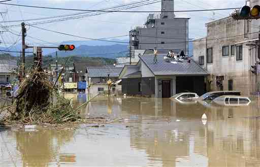 豪雨による浸水被害が発生した人吉市の中心部。屋根に避難して救助を待つ住民の姿もみられた＝２０２０年７月４日、人吉市