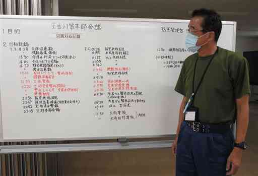 球磨村災害対策本部が７月３～４日に使ったホワイトボードを示す中渡徹防災管理官。検証のため記録は当時のまま残しているという＝１１日、同村役場