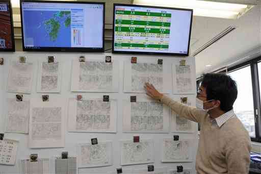 日本気象協会九州支社。壁に貼られた天気図などを見ながら気象予報を作成する＝福岡市早良区