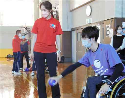 指導者と一緒にボッチャの練習に励む高峯俊さん＝１０月１６日、熊本市東区の県身体障がい者福祉センター