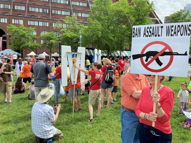 銃規制強化を求める集会で、手製の看板を掲げる市民＝6月11日、米東部マサチューセッツ州ボストン
