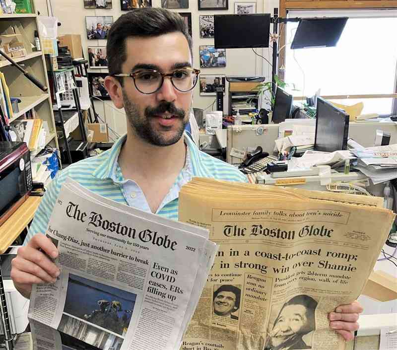 「ボストン・グローブ」の新聞を手に、米国メディアの苦境を説明するサム・ドーランさん。ボストン・グローブの紙面（左）は、約40年前の紙面（右）からページが減り、サイズも小さくなっている＝6月6日、米東部マサチューセッツ州ボストン