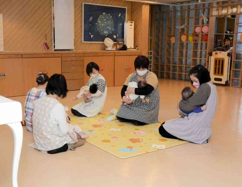 慈愛園乳児ホームで、職員に抱っこされてあやされる赤ちゃん＝熊本市中央区
