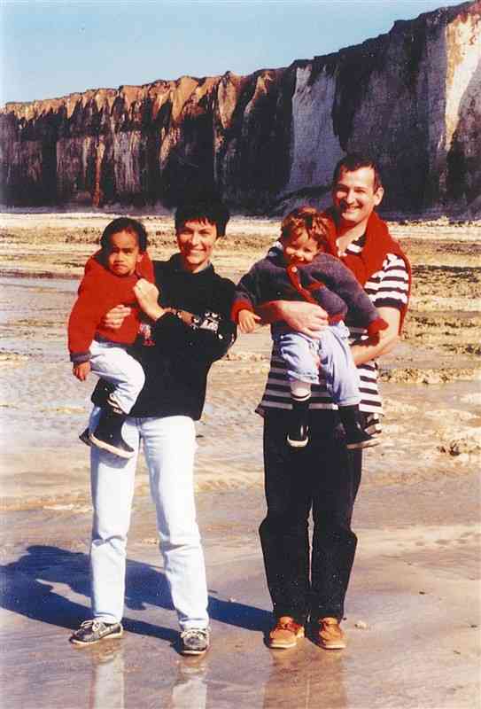 幼い頃、父親（右）に抱かれて家族写真に納まるシャルロットさん（本人提供）
