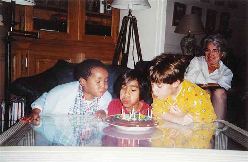子どもの頃、同じく養子縁組したきょうだいとケーキを囲むシャルロットさん（手前右）。右奥は祖母（本人提供）