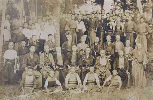 1911年、武蔵塚に集った熊本の剣術家ら。前から３列目の左から６人目のひげをたくわえた人物が平太。最前列の少年剣士の左から２人目が●［すすむ］（提供）　※●は馬へんに｢尤」