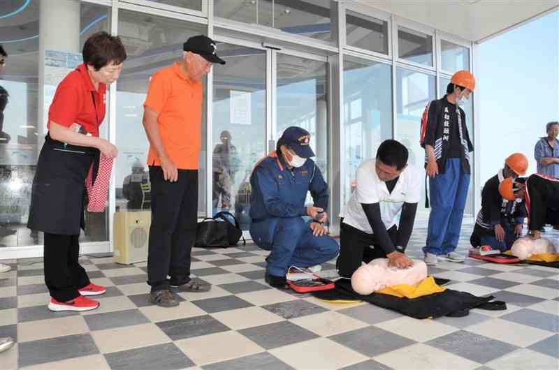 AEDの使い方や胸骨圧迫の指導を受けるイルカウオッチングの事業者ら＝天草市