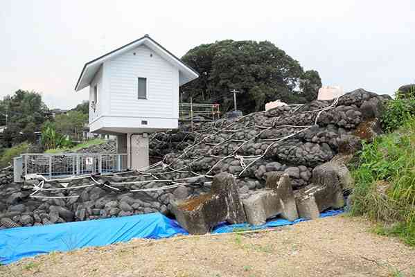 決壊箇所に大石を積んで急造された仮堤防＝２４日、人吉市中神町の球磨川右岸