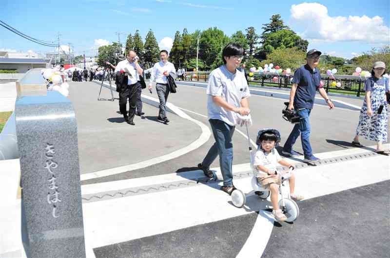 熊本地震で被災した木山橋の架け替え工事が終わり、渡り初めをする地元住民や関係者ら＝3日、益城町