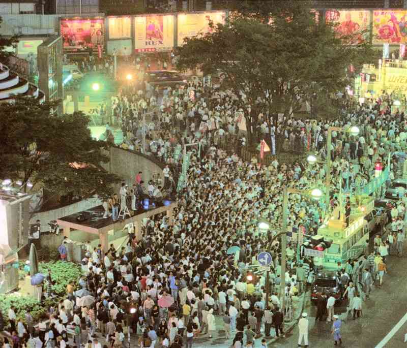 日本新党などの宣伝カーを囲み、最後の街頭演説を聞く大勢の人たち＝1993（平成5）年7月17日午後7時15分、新宿駅東口