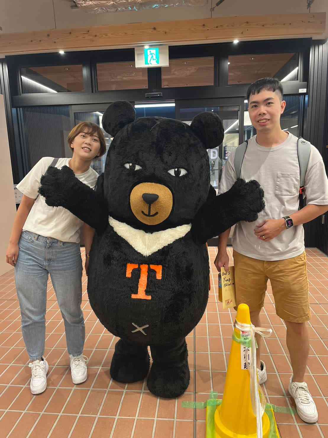 熊本空港に到着し、台湾交通部（交通省）観光署のマスコットキャラクター「オーベア」（中央）と遭遇して喜ぶ施さん夫妻