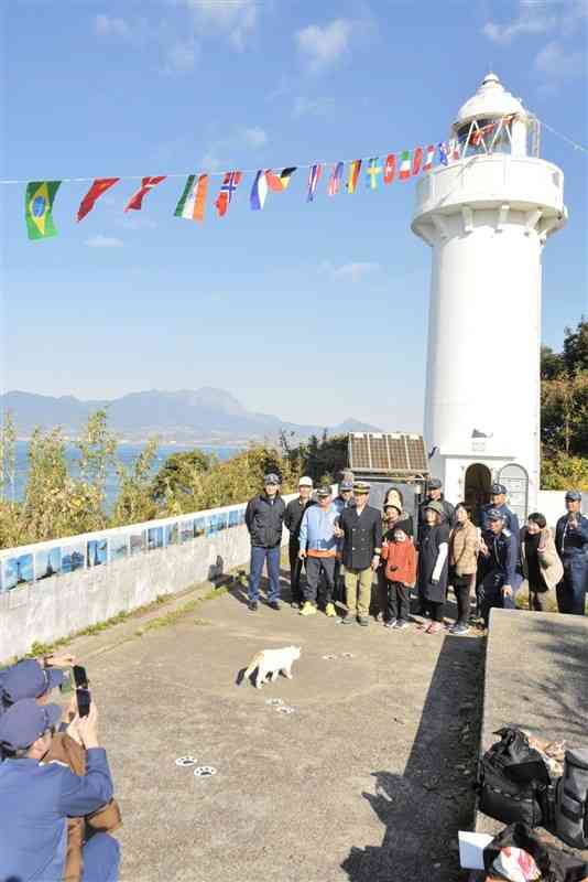 灯台で記念撮影をする海上保安友の会熊本地方支部の会員ら＝2日、上天草市