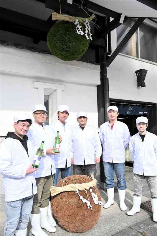 青々とした杉玉を軒先に飾り、新酒の完成を喜ぶ山村酒造の社員ら＝6日、高森町