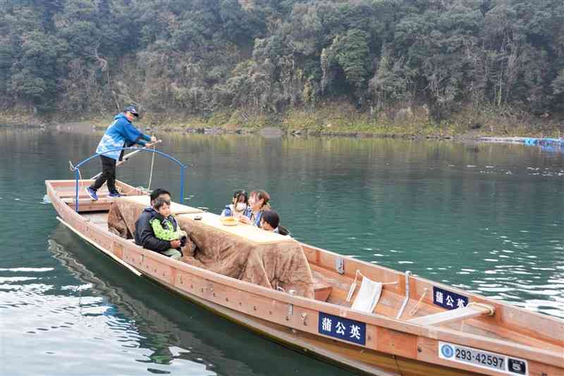 こたつ舟に乗り、球磨川からの眺めを楽しむ乗客ら＝9日、人吉市