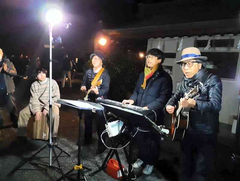 藤崎八旛宮の境内でアコースティックギターなどを使い、ライブを披露する「NOSANオールスターズ」のメンバー＝1日、熊本市中央区（梅田さん提供）