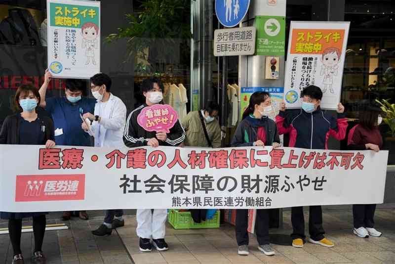 熊本県医労連のストライキに参加し、街頭で賃上げのための国の支援などを訴える看護師ら＝14日、熊本市中央区