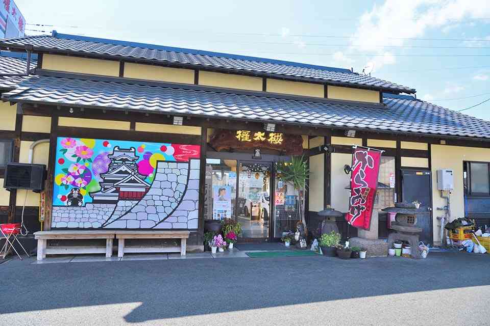 レトロなたたずまいの外観。入り口の壁面に描かれた熊本城と肥後六花の鮮やかなイラストが目を引きます