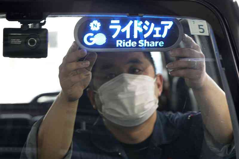 ドライバーの車両に取り付けられた「ライドシェア」の表示＝8日、東京都内