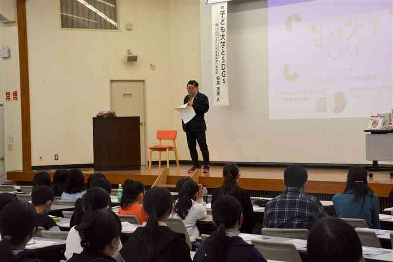 「子ども大学」の講座で小学生に語りかける稲葉茂勝さん＝3月、熊本市東区