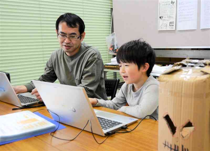「このいろスクール」で、プログラミングを学ぶ男子児童（右）＝11日、天草市