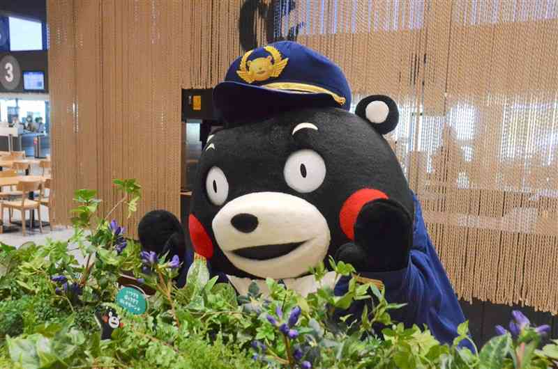 熊本空港の搭乗待合エリアに設置された「隠れくまモン」を紹介するくまモン＝12日、益城町