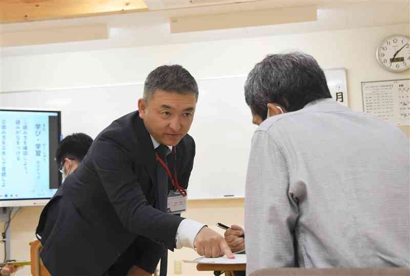 国語の授業で丁寧に指導するゆうあい中の坂本英和さん。防災教育も担当する＝19日、熊本市中央区
