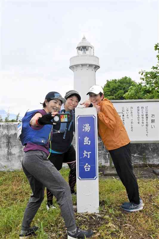 ロゲイニングで指定された場所の灯台を見つけ、到達を証明する写真を撮る参加者＝27日、上天草市