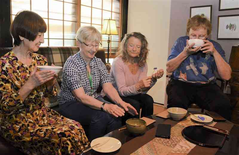 茶道体験で茶菓子とお茶を味わうドイツからの参加者ら＝29日、益城町