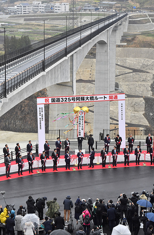テープカットとくす玉を割り、新阿蘇大橋の開通を祝う関係者ら＝2021年３月７日午後、南阿蘇村
