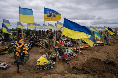 　２２日、ウクライナ東部ハリコフの墓地で死者を悼む兵士（ＡＰ＝共同）