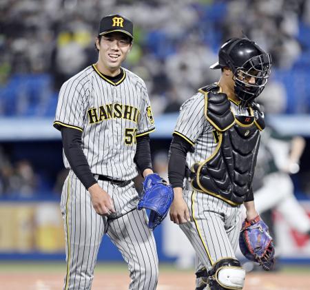 　１回２死二、三塁のピンチを切り抜け、笑顔を見せる阪神・青柳（左）。右は捕手坂本＝神宮