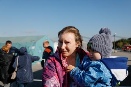 　ロシア西部ベルゴロド州に設けられたウクライナ避難民のための収容施設の敷地で子どもを抱く女性＝９月（タス＝共同）