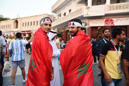 　日本の鉢巻き姿でモロッコ国旗を身にまとうサポーター＝３日、ドーハ（共同）