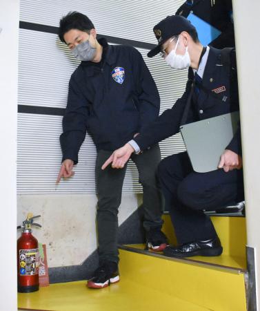 　階段に設置された消火器を確認する消防職員ら＝７日午後、東京・渋谷