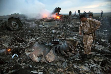 　２０１４年７月、ウクライナ東部上空で撃墜されたマレーシア航空機の残骸の中を歩く人ら（ＡＰ＝共同）