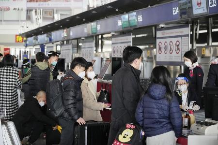 　中国入国時の隔離がなくなった１月８日、北京首都国際空港で成田行きの便の搭乗手続きをする人たち（共同）