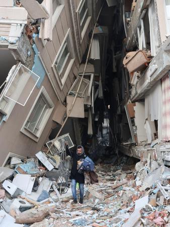 　９日、トルコ南部ハタイ県で壊れた自宅から荷物を運び出す人（ロイター＝共同）