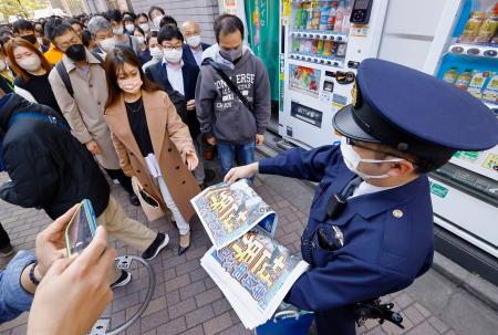 　東京・ＪＲ新橋駅付近ではＷＢＣでの日本優勝を報じる号外を求める人たちが一時、殺到した。混乱を避けるため、警察官も配布を手伝った＝２２日午後