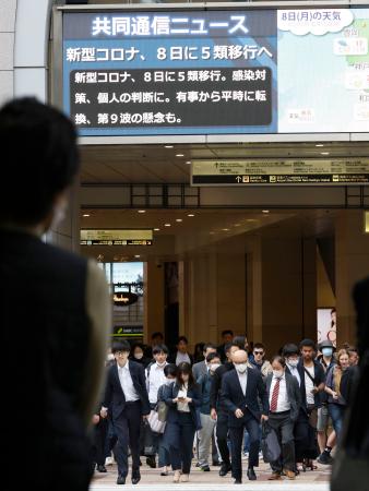 　新型コロナウイルスの感染症法上の分類が５類に移行するニュースを伝える大阪・梅田のモニター＝８日午前