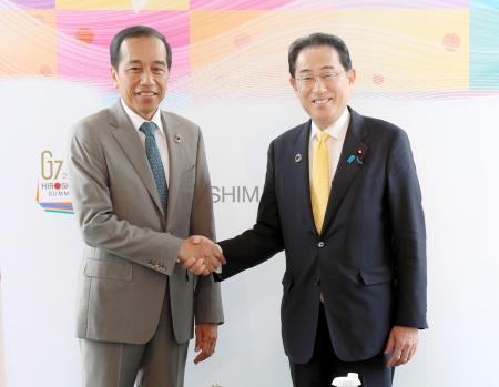 　会談を前にインドネシアのジョコ大統領（左）と握手する岸田首相＝２０日午前、広島市（代表撮影）