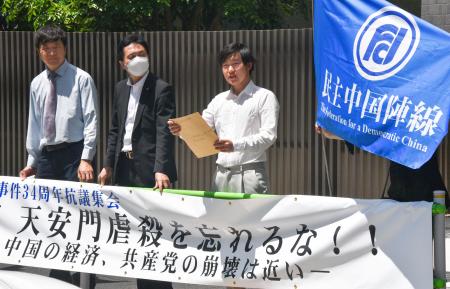 　在日中国大使館近くで、中国政府に抗議する周鋒鎖氏（左）ら＝４日、東京都港区