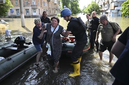 　７日、ウクライナ南部ヘルソンで、避難する人たちを助ける当局者ら（ゲッティ＝共同）