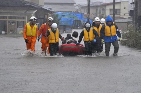 　大雨で住宅街が冠水し、ボートで運ばれる人たち＝１５日午後０時４４分、秋田市