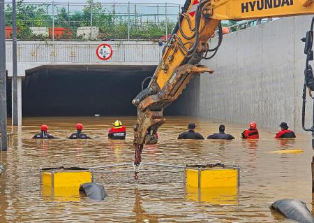 　１６日、地下道への浸水現場で救出、捜索活動を続ける消防隊員ら＝韓国中部・清州（韓国消防庁提供、聯合＝共同）